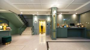 a hallway with stairs and a yellow door at The Mulberry Bangkok Khaosan Road in Bangkok