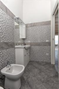 a bathroom with a toilet and a sink and a mirror at Casa negli Ulivi in Tremosine Sul Garda