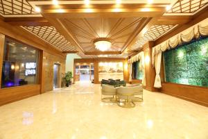 eine Lobby mit Stühlen und einer Couch in einem Gebäude in der Unterkunft Royal Peacock Hotel in Mandalay