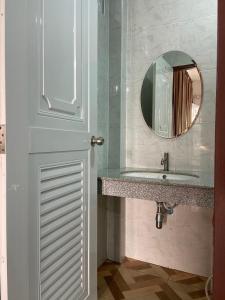 La salle de bains est pourvue d'un lavabo et d'un miroir. dans l'établissement ร่มปาล์มรีสอร์ท สระบุรี Rompalm Saraburi, à Sara Buri