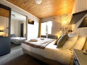 a bedroom with a bed and a large window at Hotel Le Beau Site in Auris