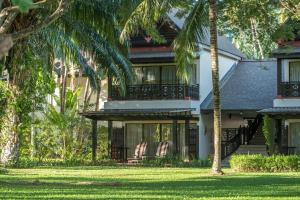 ein Haus mit Palmen davor in der Unterkunft Nexus Resort & Spa Karambunai in Kota Kinabalu