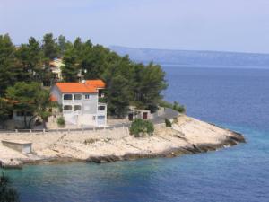 une maison sur une petite île dans l'eau dans l'établissement Apartments Gugic, à Prigradica