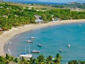 an aerial view of a beach with boats in the water at LES CHALETS DE MELINDA in Nosy Be