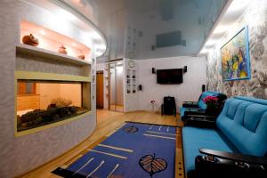 a living room with a blue couch and a fish tank at OK! Алексея Беленца 11/1 in Tomsk