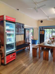 una habitación con un enfriador de bebidas, una mesa y un banco en Bondi Beach Backpackers, en Sídney