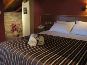 a bedroom with a bed with towels on it at Hotel Prigipikon Suites and sofites in Loutra Ipatis