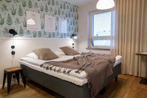 Un dormitorio con una cama con una manta encima. en Lietsu Boutique Aparthotel - Huoneistohotelli Lietsu, en Joensuu