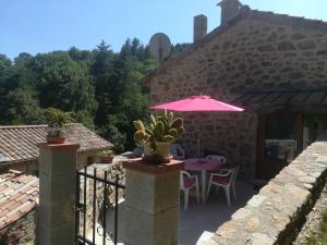 a patio with a table and an umbrella at LOFT LA ROSE DESIREE Gite 3 étoiles in Chalencon