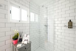a white tiled bathroom with a shower and a window at Almoura Giraldo Centro Histórico in Évora +15 photos
