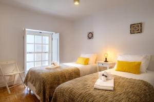 a bedroom with two beds with towels on them at Almoura Giraldo Centro Histórico in Évora