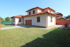 a house with a lawn in front of it at Velence Lake Apartman in Gárdony