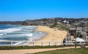 a person riding a bike on a beach at 2 Bed Bar Beach Apartment - stroll to beach & cafes, supermarket apartment number 6 in Newcastle