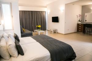 a bedroom with a large bed and a living room at Theo Sunset Bay Hotel in Paphos