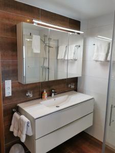 ein Badezimmer mit einem weißen Waschbecken und einem Spiegel in der Unterkunft Ferienhaus Haidweg, Wohnung 2 in Haidmühle