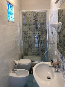 ein Bad mit einem Waschbecken, einem WC und einer Dusche in der Unterkunft 100 passi dal mare in Agropoli