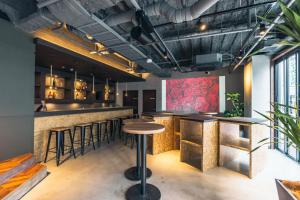 bar z drewnianymi blatami i stołkami barowymi w obiekcie DOYANEN HOTELS BAKURO w Osace