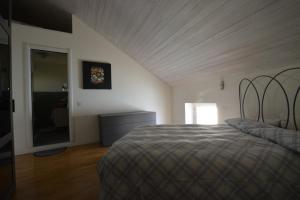 1 dormitorio con cama, tocador y espejo en La mia mansarda, en Biella