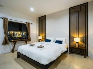 Ban Nong SrahにあるNararin Garden Houseの大きな白いベッドと窓のある寝室