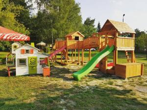een speeltuin met een glijbaan en een speelhuis bij Firlej Plaża in Firlej