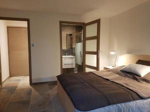 a bedroom with a large bed and a kitchen at Le Domaine de Wail - Legends Resort in Wail