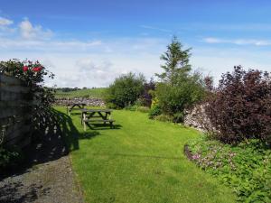 
a grassy area with benches and trees at The Black Bull at Nateby in Kirkby Stephen
