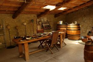 a room with a wooden table with chairs and wine barrels at Casina Di Cornia in Castellina in Chianti