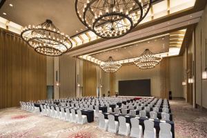 una sala de conferencias con sillas y una pantalla en Crowne Plaza QingdaoOrientalMovieMetropolis, an IHG Hotel, en Huangdao