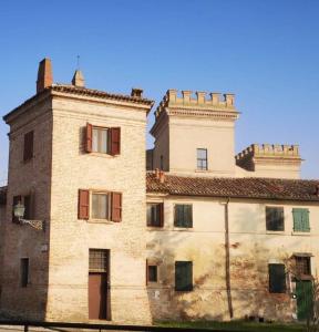 an old brick building with two towers on top of it at La Torretta, una casa inaspettata in Mesola