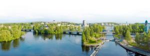a river with trees and a bridge in a city at Lietsu Boutique Aparthotel - Huoneistohotelli Lietsu in Joensuu