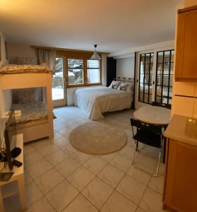 a bedroom with a bed and a desk and a table at Studio Brunnmatt in Zermatt +2 photos