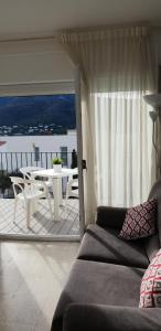 ein Wohnzimmer mit einem Sofa und einem Tisch auf dem Balkon in der Unterkunft El Far, Apartamento con vistas al mar L3 in Port de la Selva