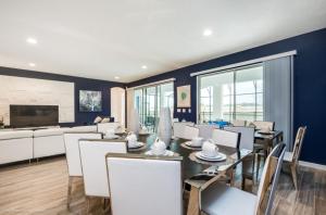 a dining room with a table and white chairs at Varios Resort Pool Homes in Davenport
