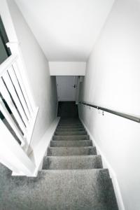 a staircase in a building with white walls and concrete stairs at 4a Smart Apartments in Newark-on-Trent