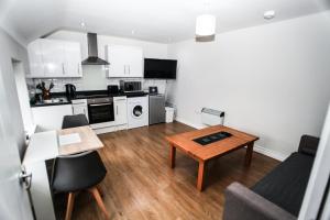 a living room with a table and a kitchen at 4a Smart Apartments in Newark-on-Trent