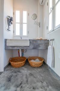 a bathroom with a sink and two baskets at On The Rocks in Symi