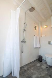 a bathroom with a shower curtain and a toilet at On The Rocks in Symi