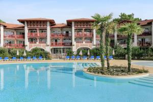 ein Resort mit einem großen Pool und Palmen in der Unterkunft Résidence Pierre & Vacances Le Domaine de Gascogne in Biscarrosse