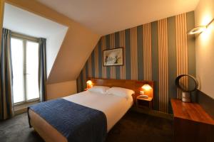 Habitación de hotel con cama y ventana en Relais du Pré, en París