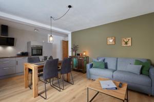 a living room with a couch and a table at Landhaus Herzogsteig in Krün