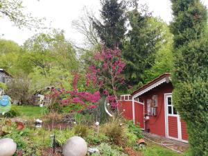 a red shed with a tree in a garden at Haus Maria in Fischbach