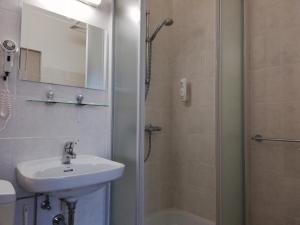 a bathroom with a sink and a shower at Logies Het Maantje in De Panne