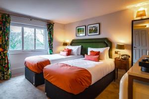 a bedroom with two beds with red pillows at Aragon House in London