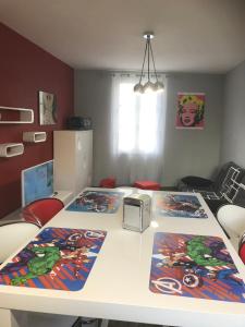 una habitación con una mesa con dos esteras. en APPARTEMENT STYLE POP ART avec GARAGE CENTRE HISTORIQUE BEZIERS, en Béziers