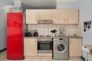 a kitchen with a washing machine and a red refrigerator at Four Seasons Apartments in Cape Town
