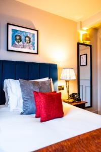 1 dormitorio con 1 cama blanca y 2 almohadas rojas en Aragon House, en Londres