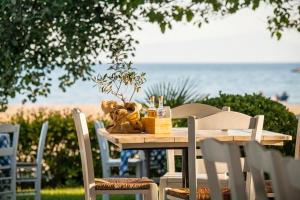 uma mesa de madeira com cadeiras e uma mesa com vista para a praia em Beautiful house em Epanomi