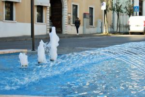 a water fountain with three polar bears on the street at Hotel Ristorante Commercio in Salò