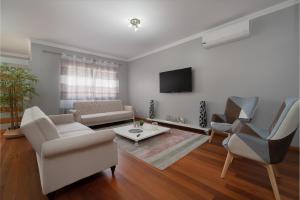 a living room with a couch and chairs and a tv at Charming Villa in Funchal in Funchal