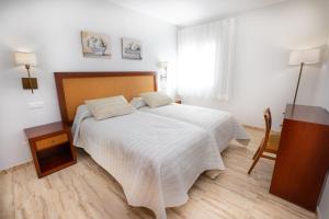 1 dormitorio con 1 cama y suelo de madera en Apartamentos Jimmy, en Nerja